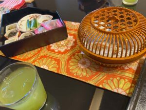 冷たい緑茶に籠の中のお茶菓子と、おつまみのお重も。