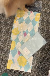 白と水色のひし形をベースに、黄色い大きめの花柄の浴衣。アクセントは青みピンク。