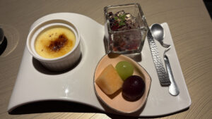 魔法の絨毯のように波打った形のお皿の上に、クレームブリュレ、ミックスベリーのジュレ、巨峰、シャインマスカット、黄肉メロン