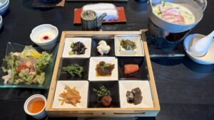 サラダとドレッシング、正方形の木のお盆に乗った9つの四角い小皿、豆乳鍋。