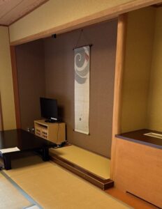 床の間に置かれたテレビと掛け軸。掛け軸の図柄は、雷様らしきひとが太鼓を釣り上げている様子。