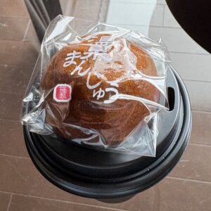 コーヒーのペーパーカップの蓋の上に、温泉まんじゅうを乗せてみた。