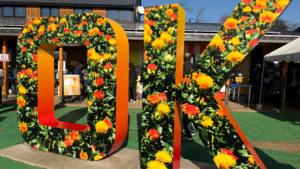 「OK」をかたどったオブジェ。表面には、べに花の写真がプリントされている。