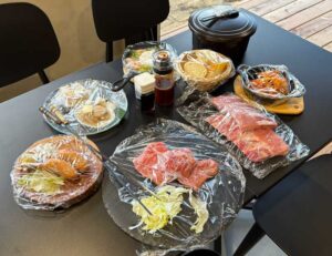 骨付きウインナー、ホタテバター、武州和牛ステーキ、ポークバックリブ、スパイシーチキン、アヒージョ、バゲット、おひつごはんが一同に会するテーブル